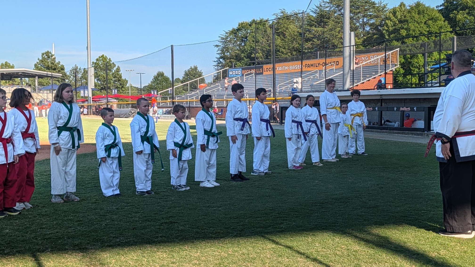 The full line of Karate USA students standing at attention on the field, facing their instructor.