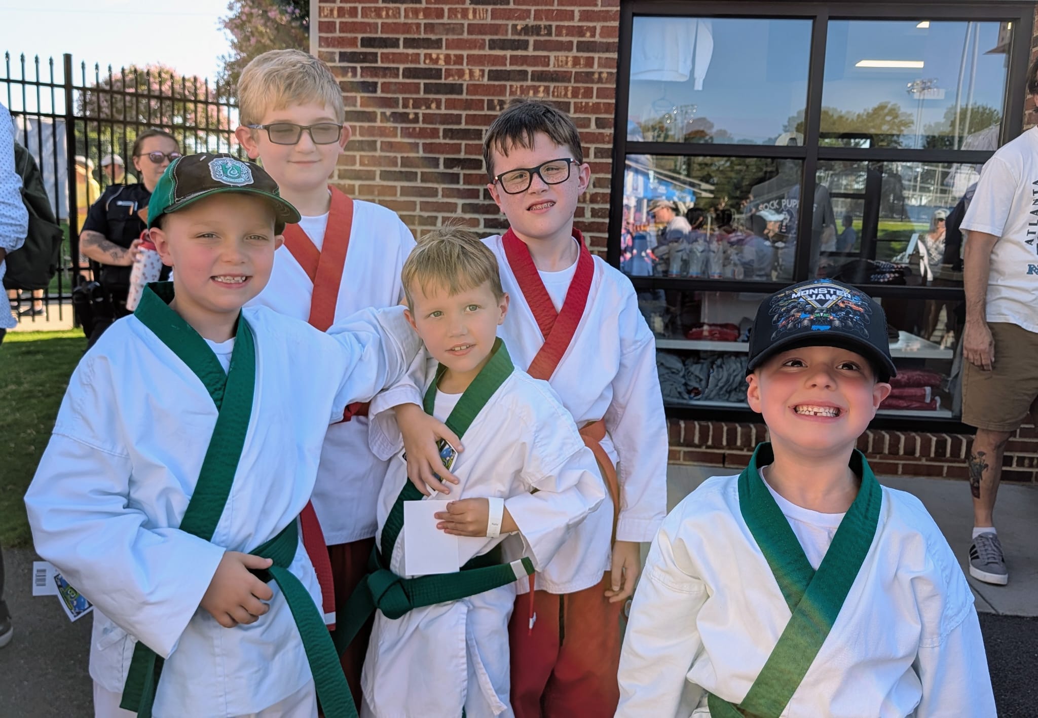 Five young Karate USA students in uniform grinning outside the Sock Puppets team store.